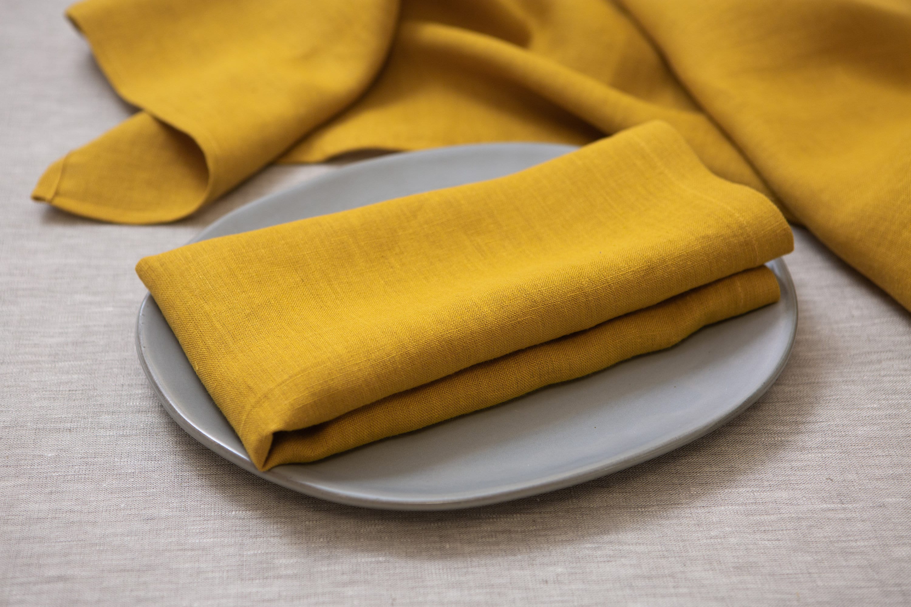 Organic linen napkins in a rich mustard color bring a touch of warmth and sophistication to your dining experience. Made from high-quality, sustainably sourced linen, these napkins are not only aesthetically pleasing but also environmentally friendly.  With their soft, luxurious texture, these napkins provide a delightful tactile experience while adding an elegant element to your table setting.