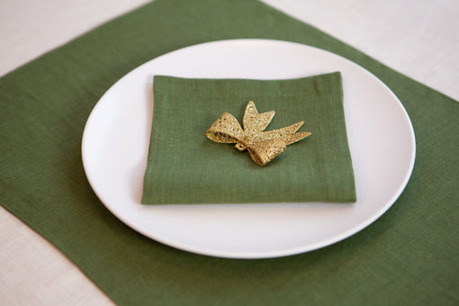 Green linen placemat set for a Christmas dinner table