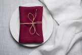 Plum linen napkin tied with jute twine on a white plate – Halloween dinner decor
