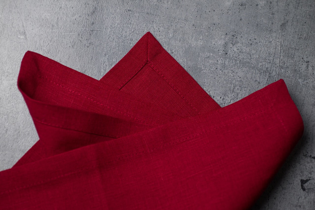 Folded wine red linen napkins on concrete – stonewashed linen texture