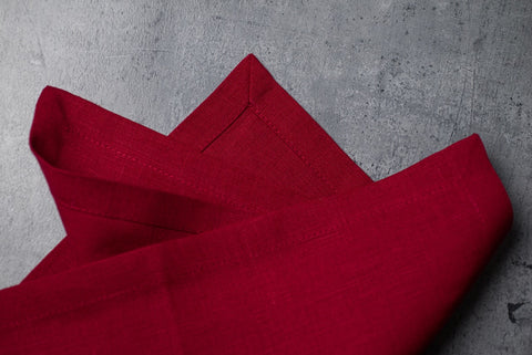 Folded wine red linen napkins on concrete – stonewashed linen texture