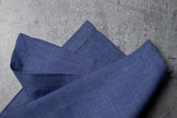 Deep blue linen fabric close-up with mitered hem corner