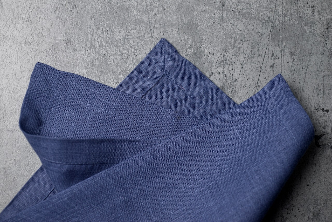 Deep blue linen fabric close-up with mitered hem corner