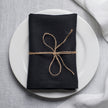 Black linen napkin with mitered corners on table setting, organic flax cloth napkin for elegant dining and modern home decor
