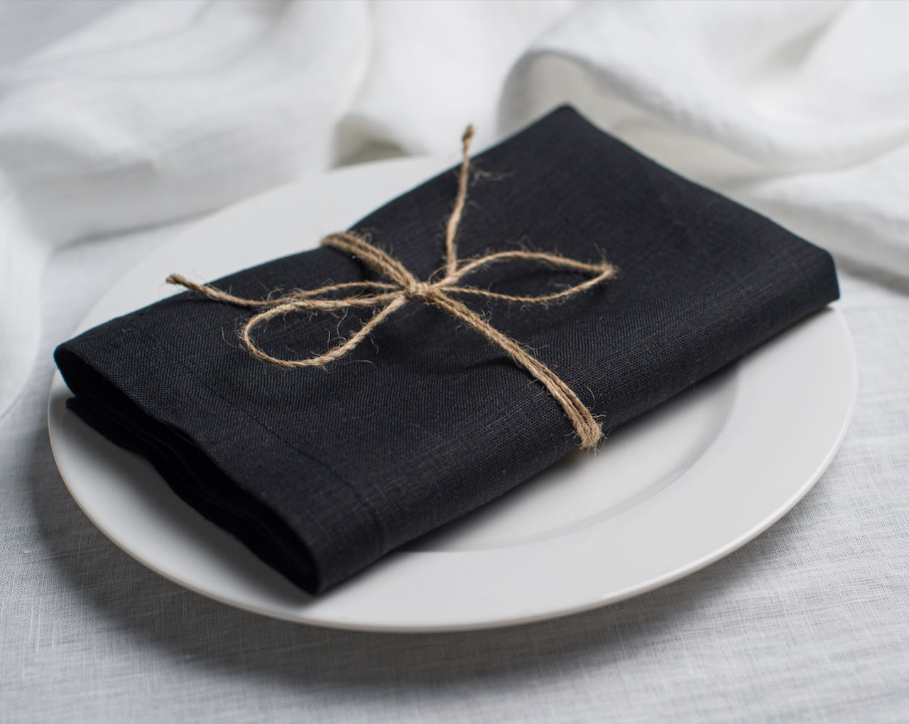 Black cloth linen napkin with clean edges, minimalist table setting decor, sustainable reusable napkin for modern dining