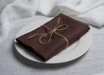 Cacao brown linen napkin tied with jute twine on a white plate – Halloween table setting