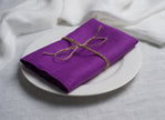 Violet organic linen napkin tied with jute twine on a white plate – Halloween table decor