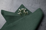 Green basil cloth linen napkin folded on plate, organic flax fabric table decor, sustainable reusable napkin for modern table setting