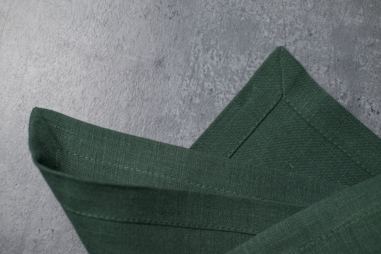 Green basil reusable linen napkin on white plate, premium flax table linen for eco friendly dining, minimalist table styling