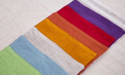 Linen cocktail napkins fanned out in a rainbow of colors