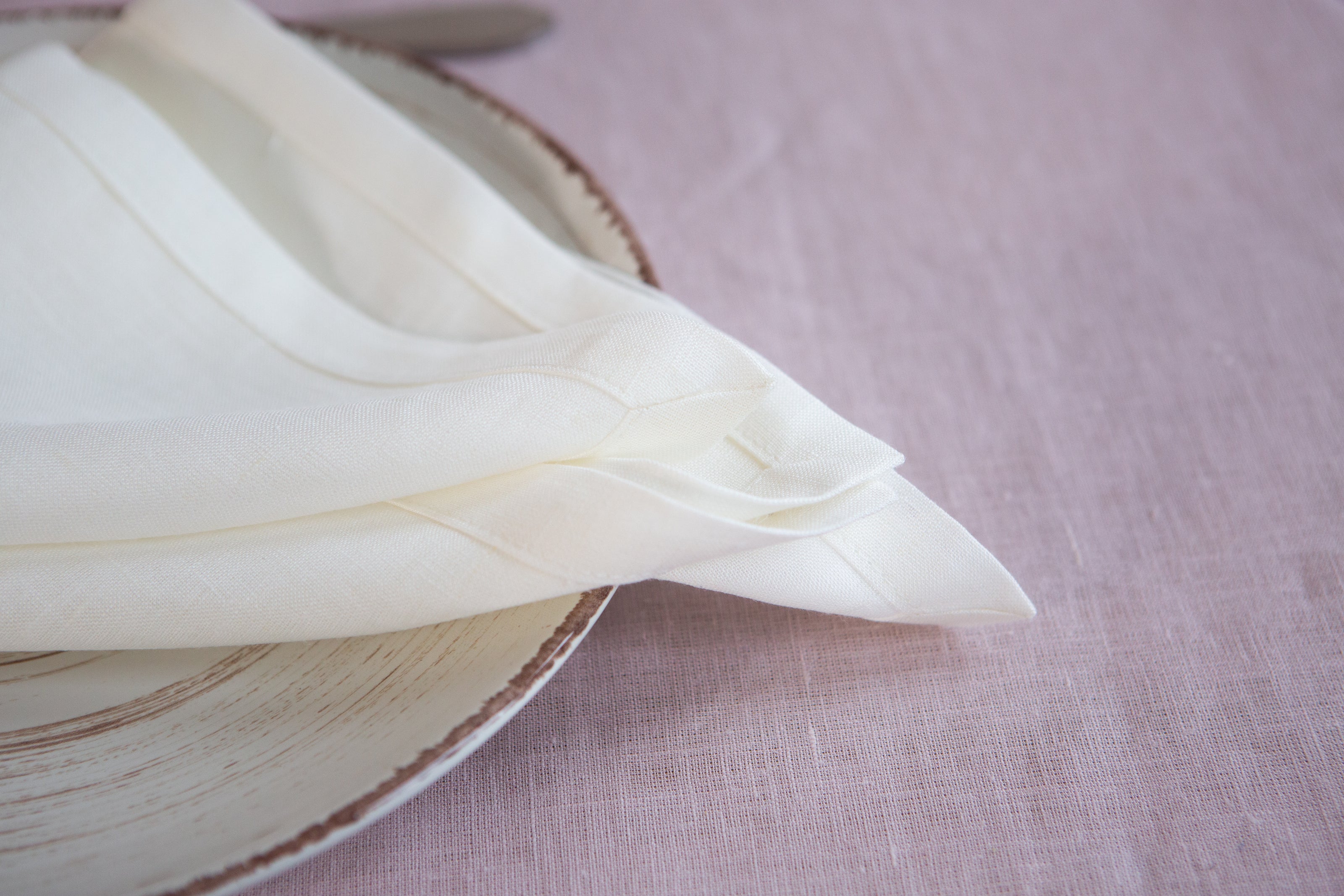 Classic white organic linen napkins with mitered corners. Timeless, sustainable, and perfect for any table setting.