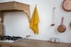 Mustard linen kitchen towel in a rustic kitchen – Thanksgiving hostess gift idea