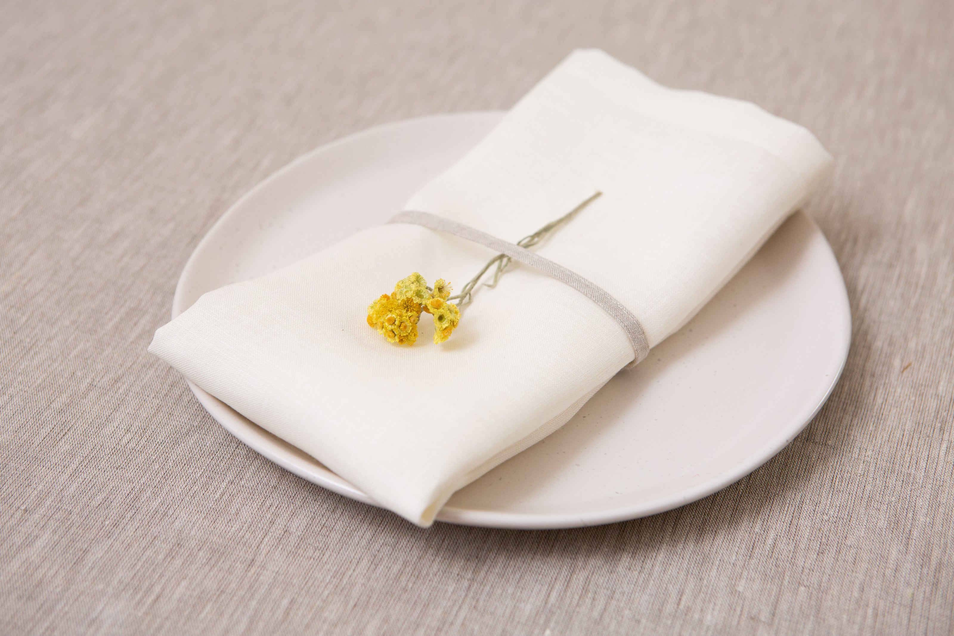 Reusable white linen napkins crafted from 100% organic fabric. A timeless, eco-friendly choice for every table. Holiday home decor.