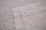 Close-up of Natural beige linen fabric showing its woven texture and mitered hem