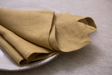 Honey-colored organic linen napkins – create a natural, sustainable dining atmosphere for your next holiday gathering, featuring a timeless design.