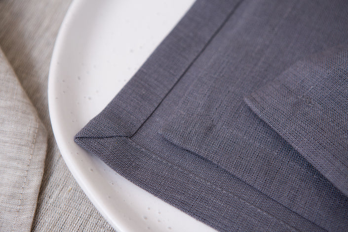 Elegant grey organic linen napkins with mitered corners. Sustainable, reusable, and perfect for lunch, dinner, or cocktails.