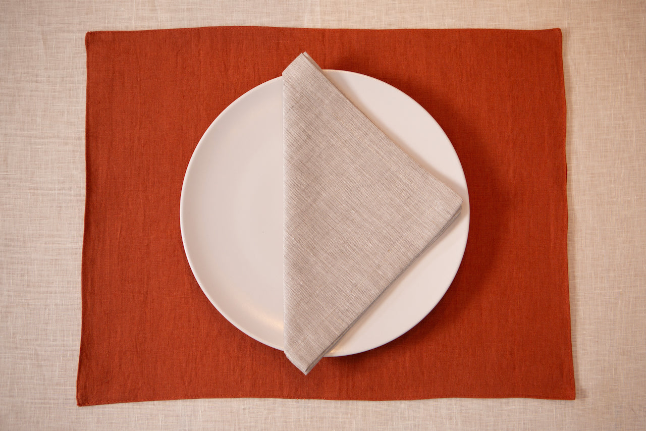 Terracotta linen placemat with a natural linen napkin and white plate – Thanksgiving place setting