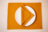 Mustard linen placemat with a matching mustard linen napkin and white plate – cozy fall table