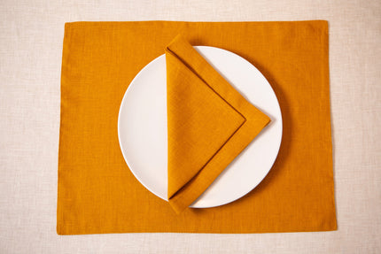 Mustard linen placemat with a matching mustard linen napkin and white plate – cozy fall table