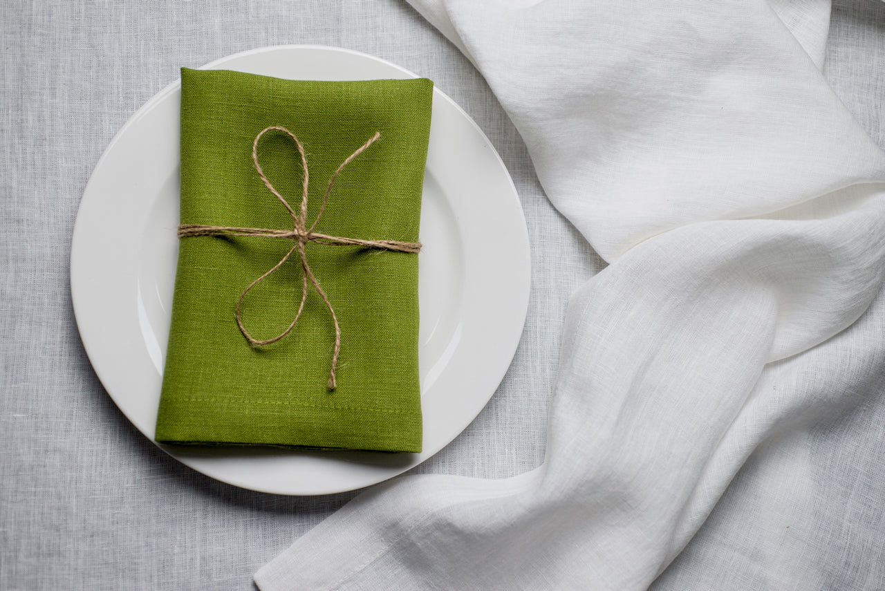 Pear green organic linen napkin arranged for an elegant Easter table setting. The muted spring green tone pairs beautifully with florals and neutral ceramics for sophisticated holiday decor. Crafted from eco-friendly natural linen for timeless and sustainable entertaining.