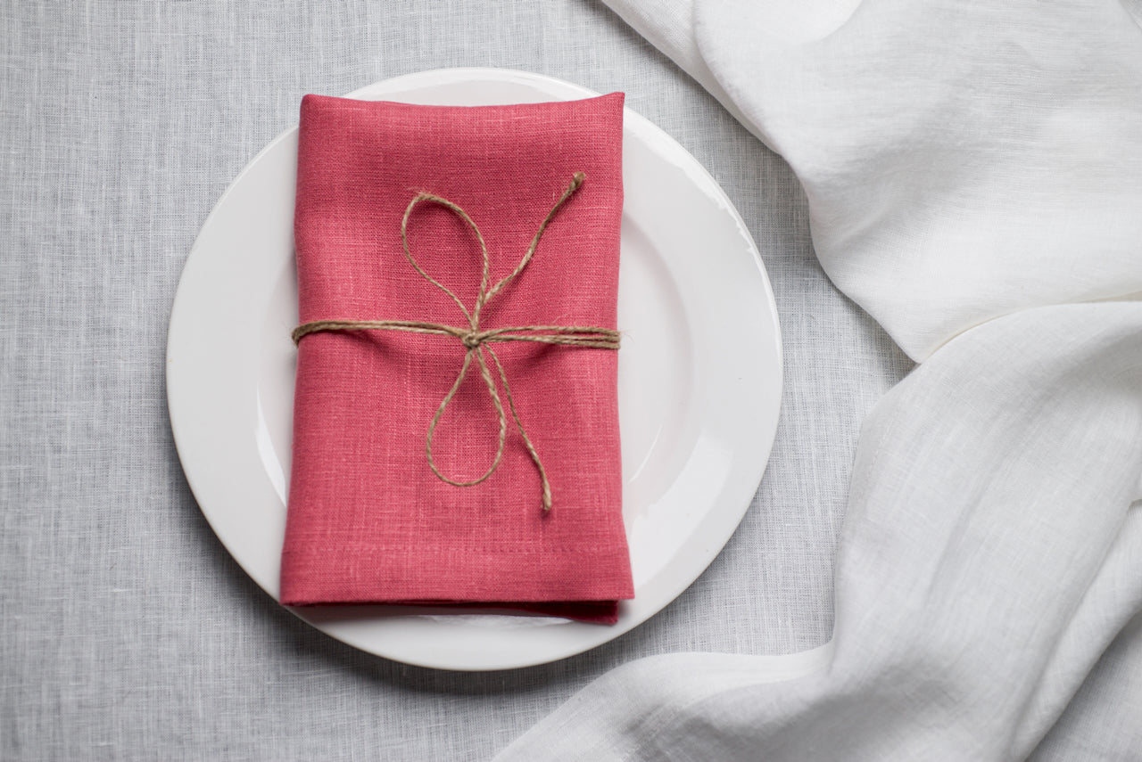 Salmon organic linen napkin arranged for Easter dinner table decor. The warm pink tone adds romantic spring energy to holiday entertaining. Crafted from premium natural linen for sustainable and reusable table styling.
