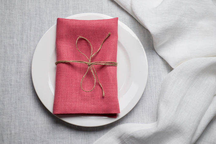 Salmon organic linen napkin arranged for Easter dinner table decor. The warm pink tone adds romantic spring energy to holiday entertaining. Crafted from premium natural linen for sustainable and reusable table styling.