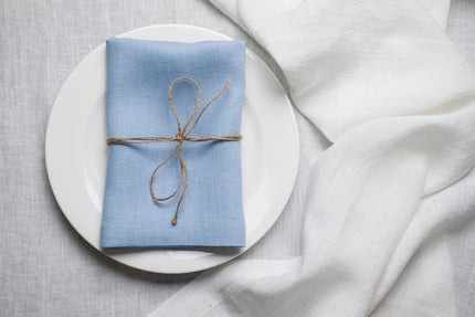 Sky blue organic linen napkin prepared for Easter brunch table styling. The pastel tone reflects spring light and pairs beautifully with white ceramics and fresh flowers. Reusable natural linen textile for conscious seasonal decor.