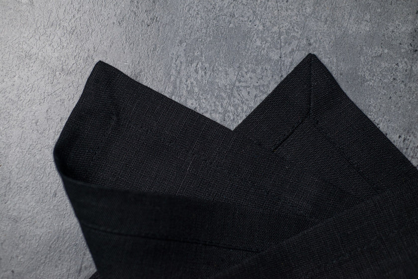 Black linen fabric close-up with mitered hem corner – CoolLinen color 1. Black