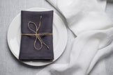 Slate linen napkin tied with jute twine on a white plate