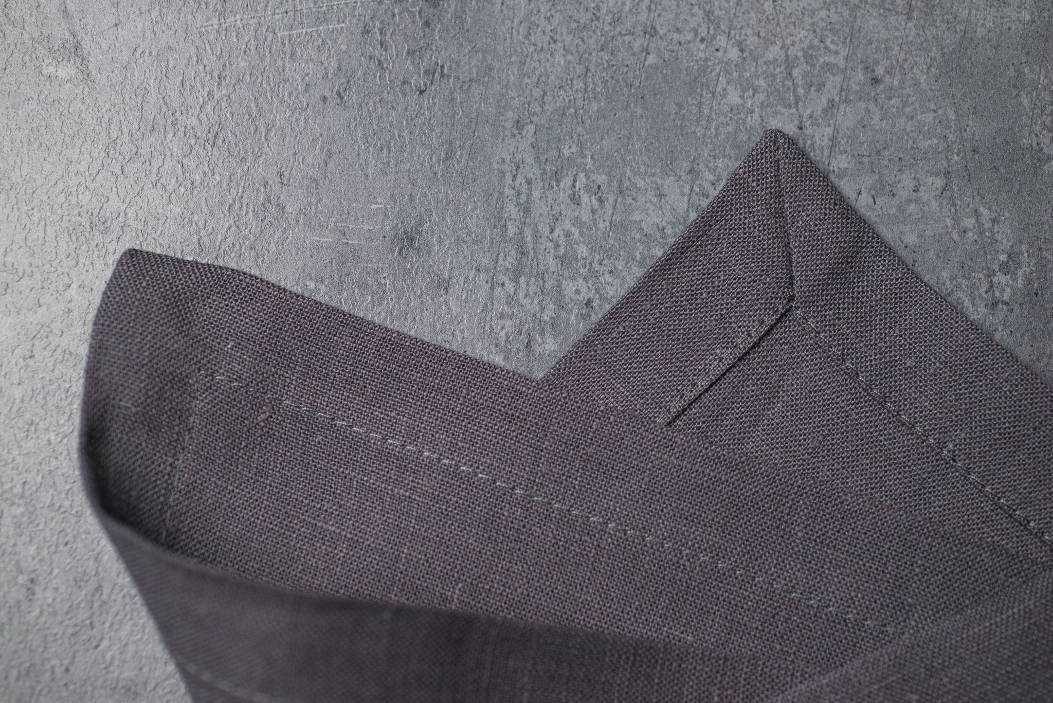 Grey linen fabric close-up with mitered hem corner – CoolLinen color 3. Grey
