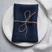 Old Navy linen napkin tied with jute twine on a white plate