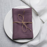Fog linen napkin tied with jute twine on a white plate