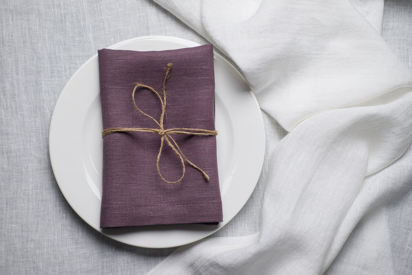Fog linen napkin tied with jute twine on a white plate
