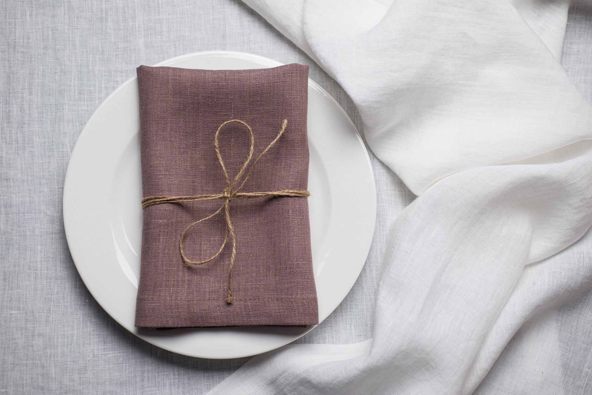 Limed Oak linen napkin tied with jute twine on a white plate