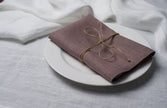 Limed Oak linen napkin tied with jute twine on a white plate, side view