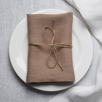 Oat linen napkin tied with jute twine on a white plate