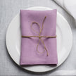 Lavender linen napkin tied with jute twine on a white plate