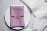 Lavender linen napkin tied with jute twine on a white plate