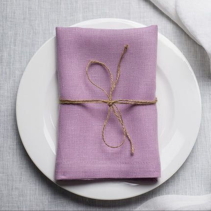 Lavender linen napkin tied with jute twine on a white plate