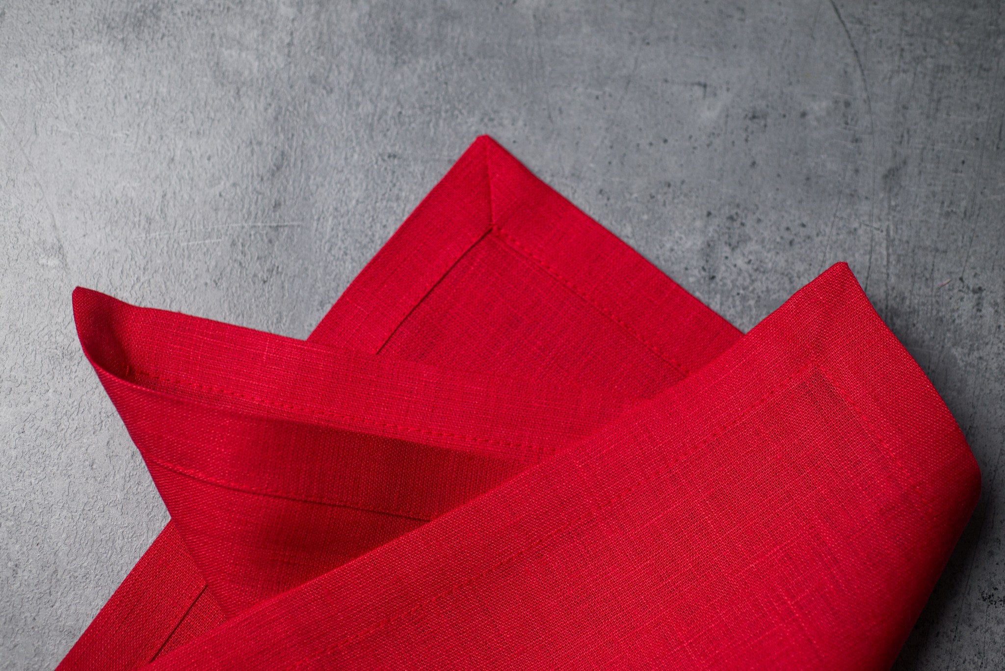 Red linen fabric close-up with mitered hem corner – CoolLinen color 27. Red
