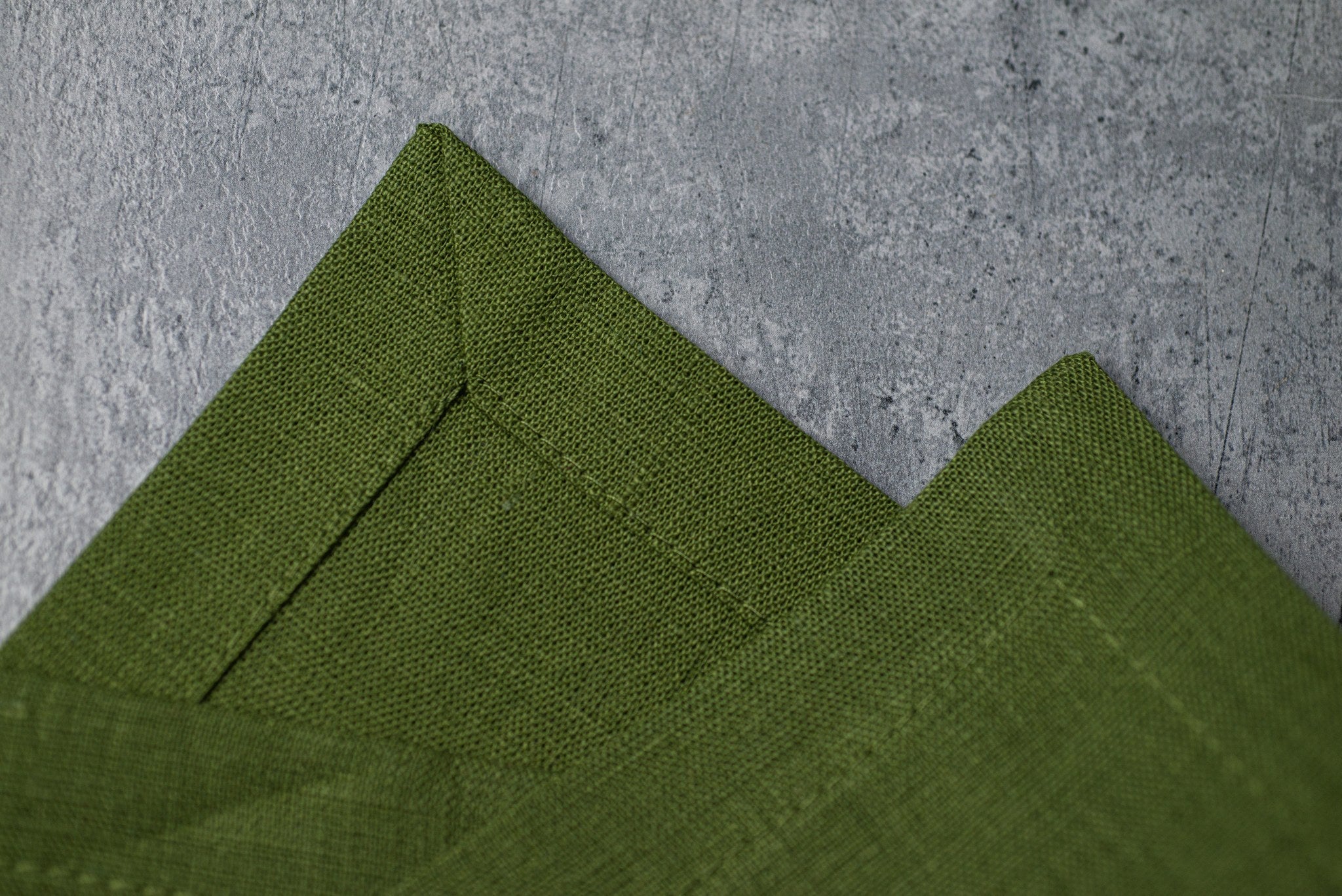 Green linen fabric close-up with mitered hem corner – CoolLinen color 32. Green