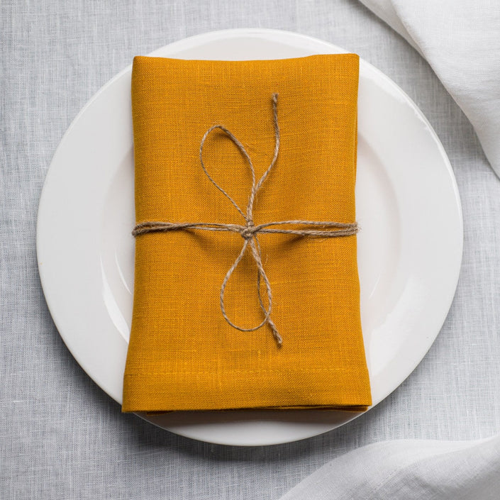 Canary linen napkin tied with jute twine on a white plate