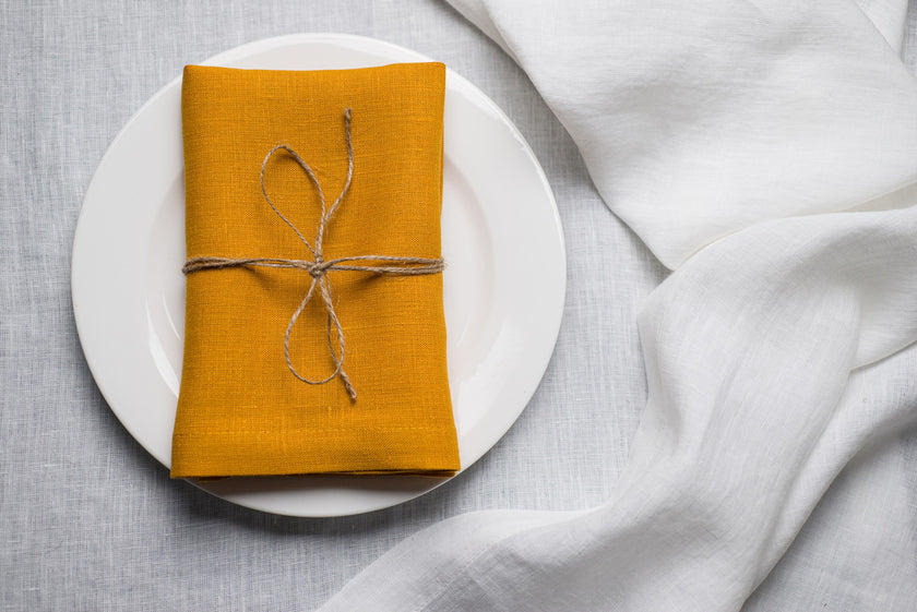 Canary linen napkin tied with jute twine on a white plate
