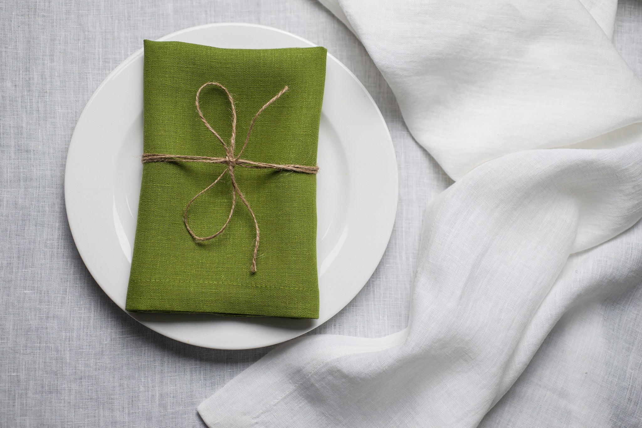 Pear linen napkin tied with jute twine on a white plate