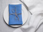 Electric linen napkin tied with jute twine on a white plate