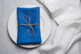 Electric linen napkin tied with jute twine on a white plate