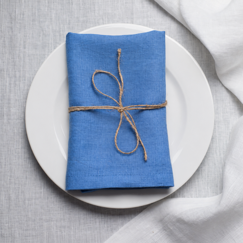 Electric linen napkin tied with jute twine on a white plate